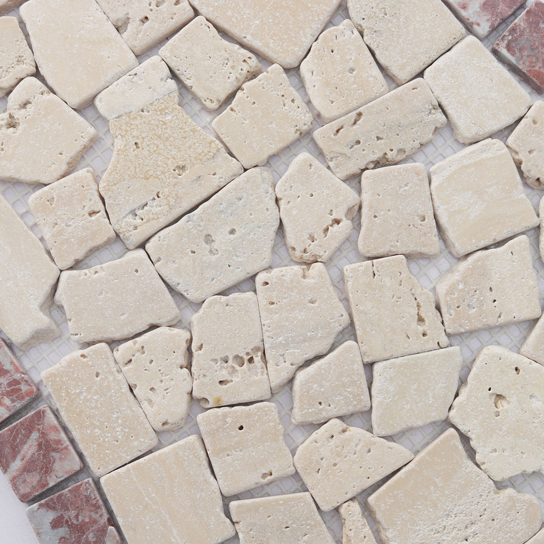 Detailed texture of the beige tumbled stone irregular mosaic.