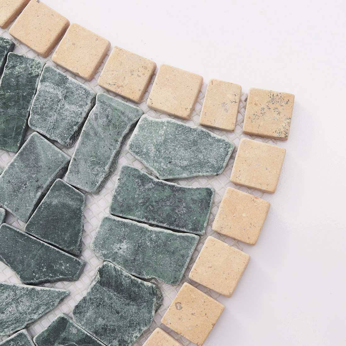 Close-up of the edge of green marble irregular mosaic tile.