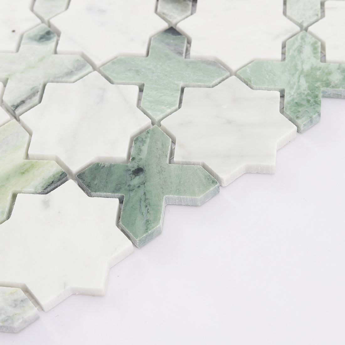 Close-up of bottom chips of marble star cross mosaic tile.