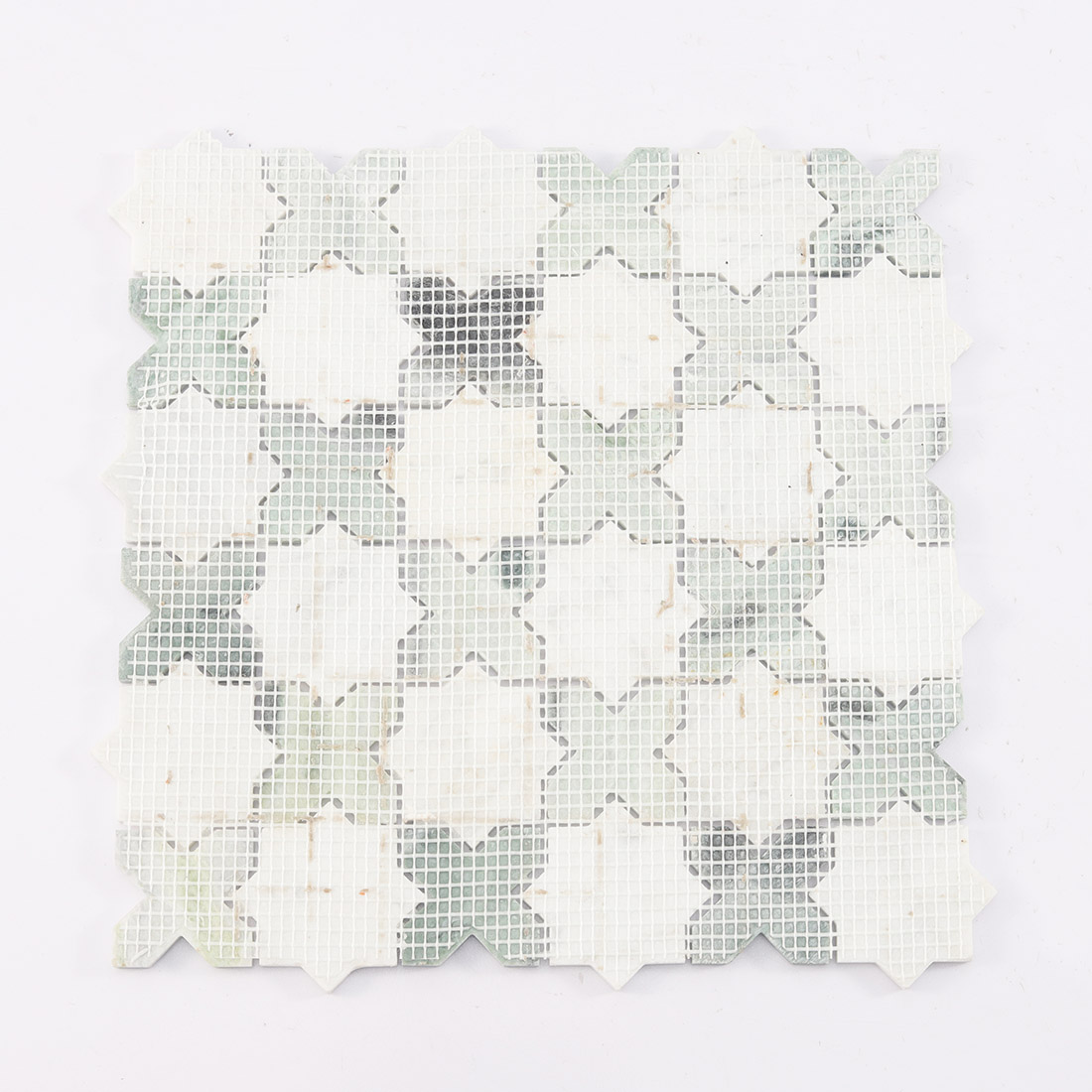 Mesh backing on the reverse side of marble star cross mosaic.