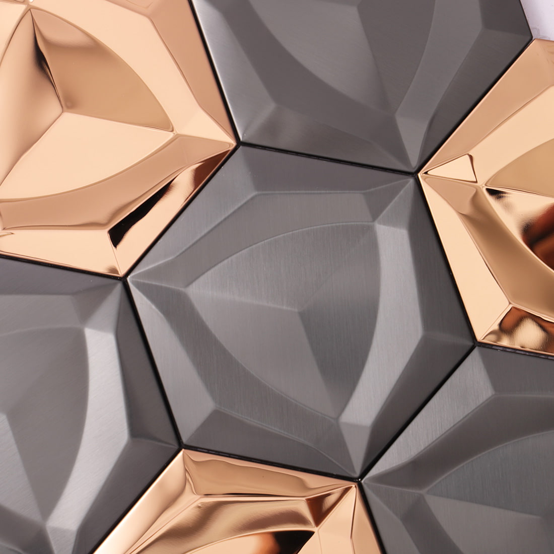 Surface detail of 3D faceted matte black metallic mosaic tiles.