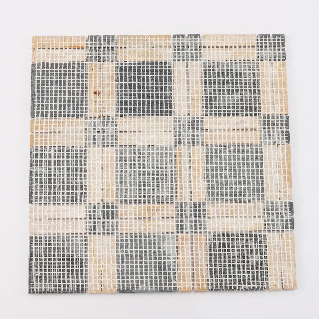 Back view of black and yellow marble mosaic tile sheet with fiber mesh backing