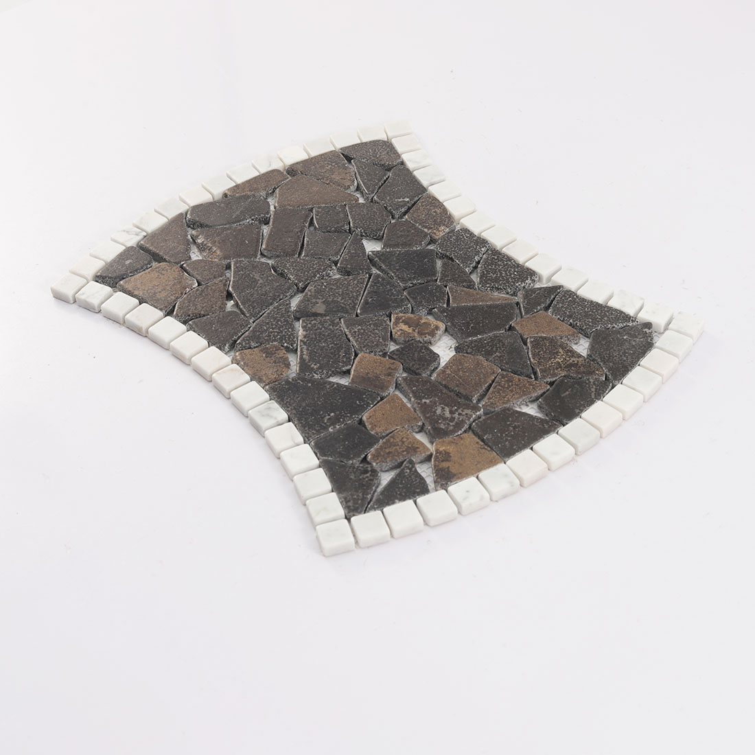 Angled view of dark brown irregular stone mosaic tile with white border