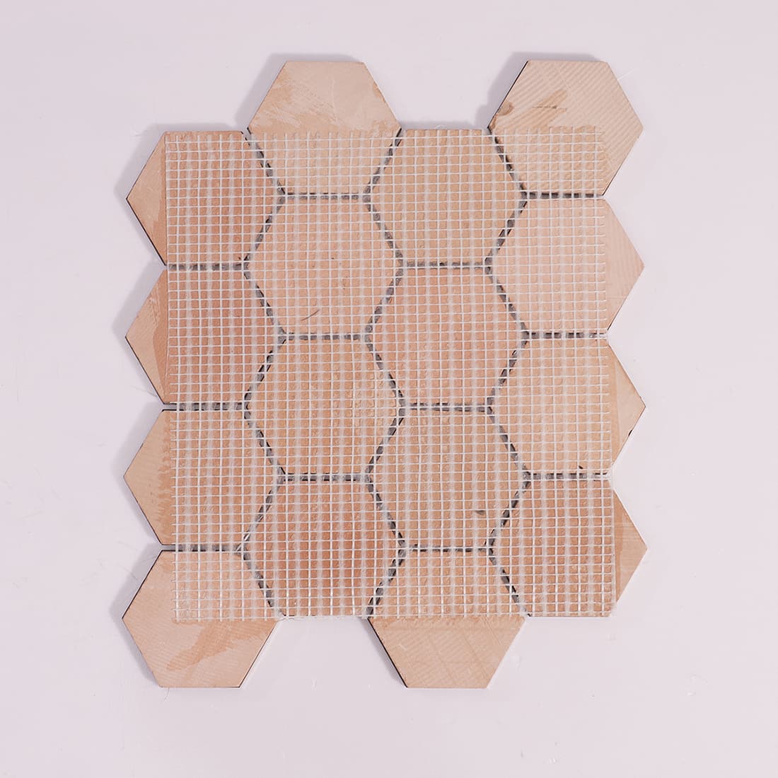 The back of the mosaic tile sheet showing the white mesh netting used for easy installation