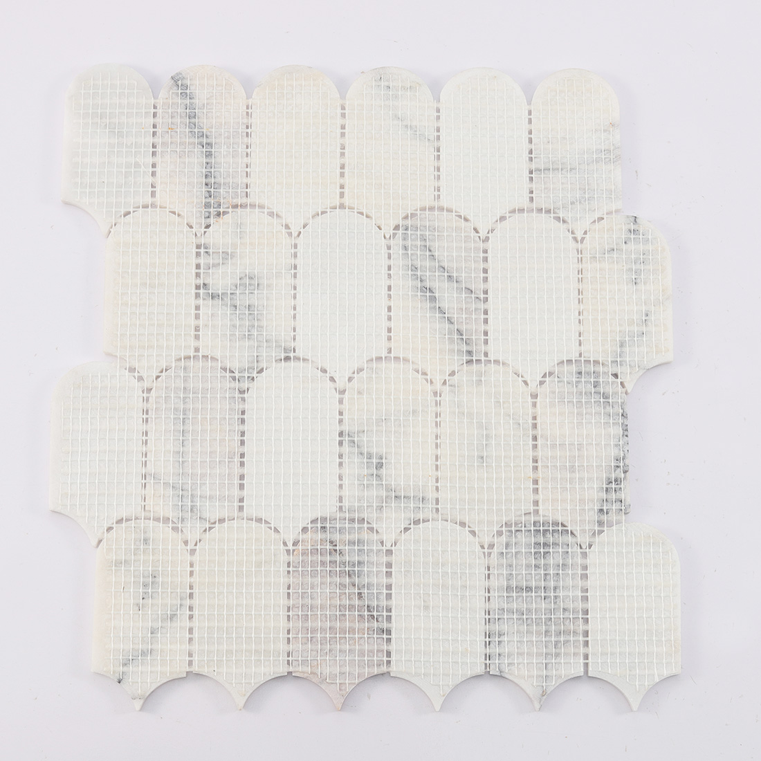 Back view of white arched marble mosaic tile with fiber mesh backing