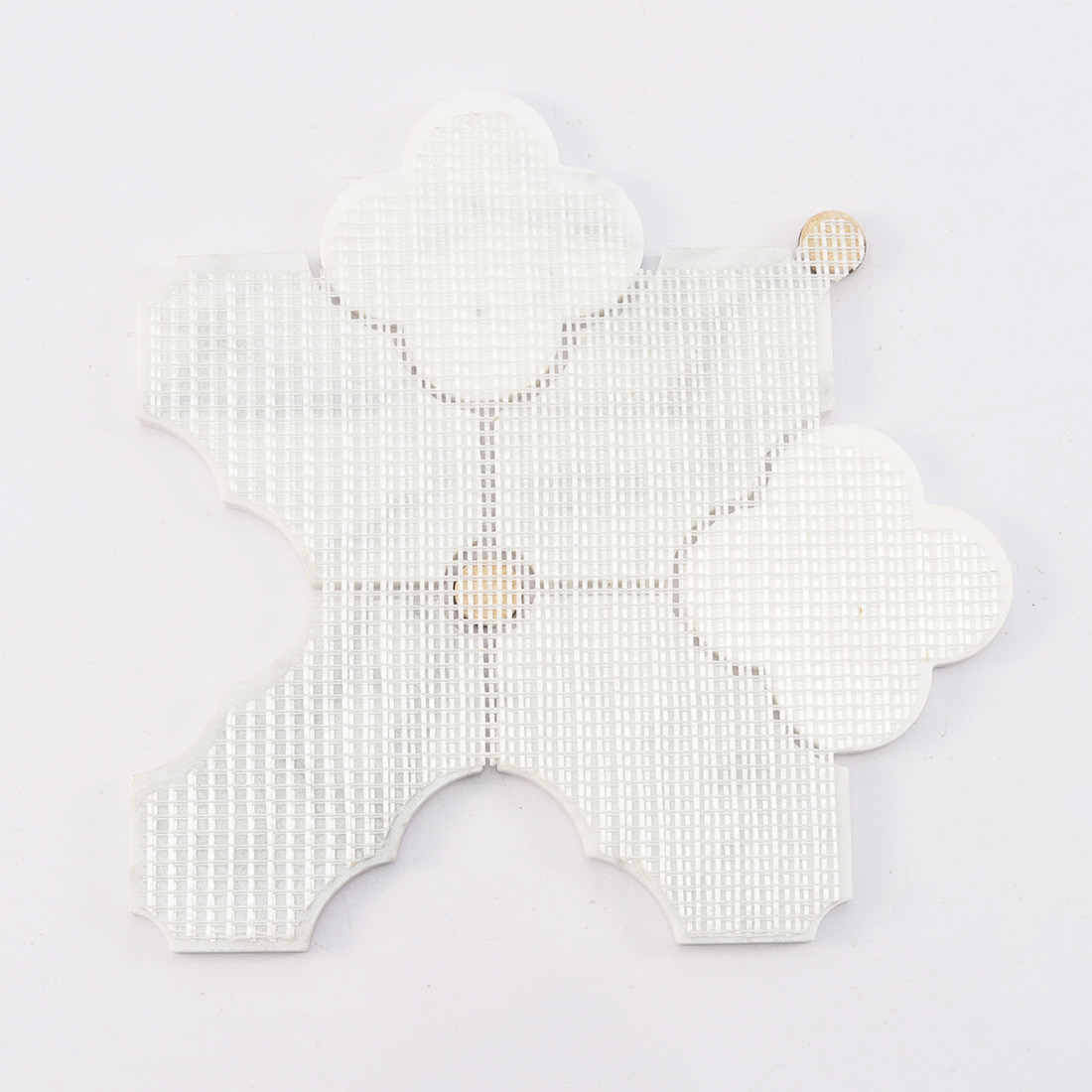 Back view of white marble arabesque tile with mesh backing and gold inserts