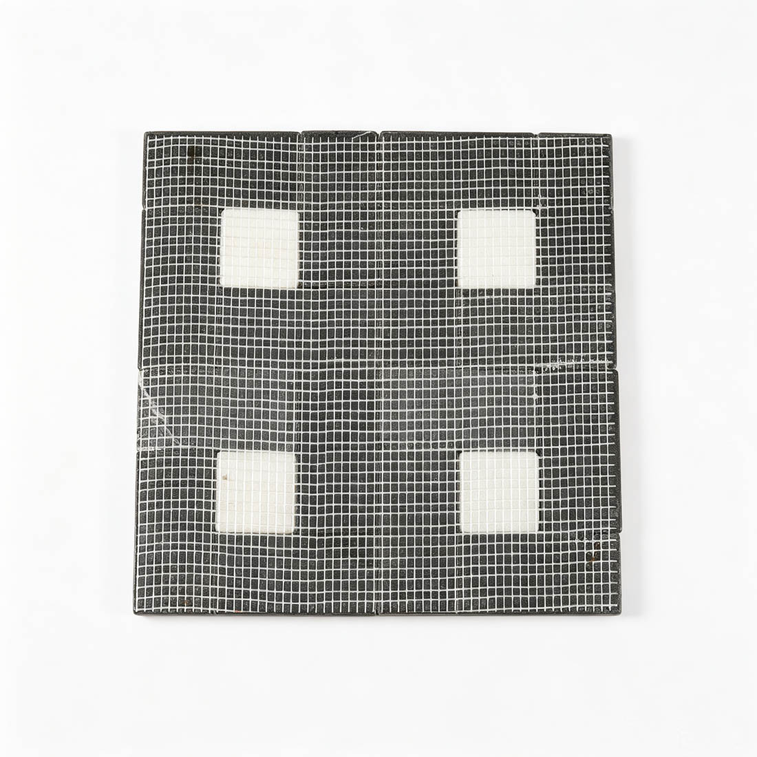 Mesh backing on the reverse side of black marble mosaic sheet