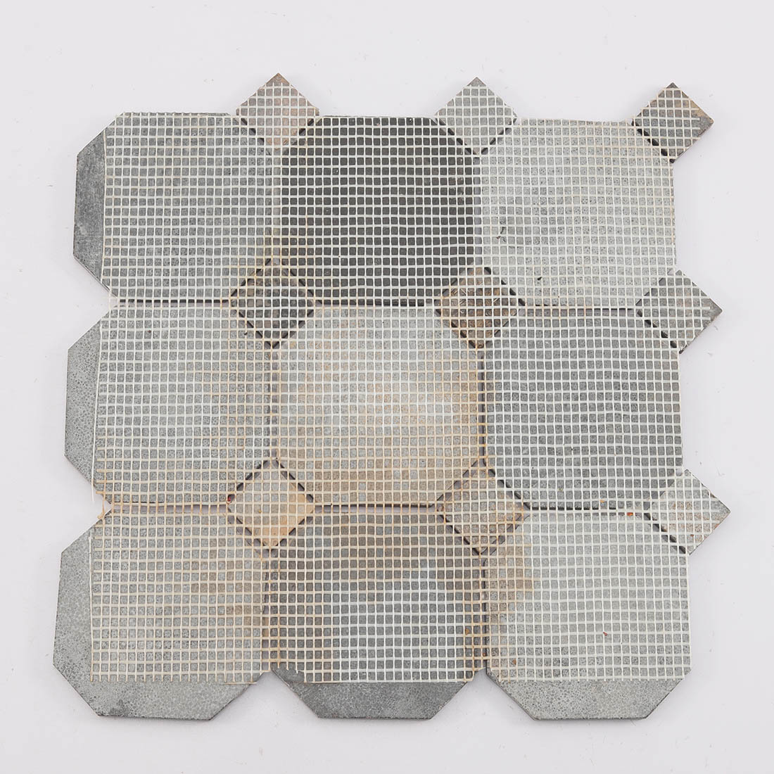 The back view of an octagon dark brown stone mosaic tile sheet showing the mesh backing.
