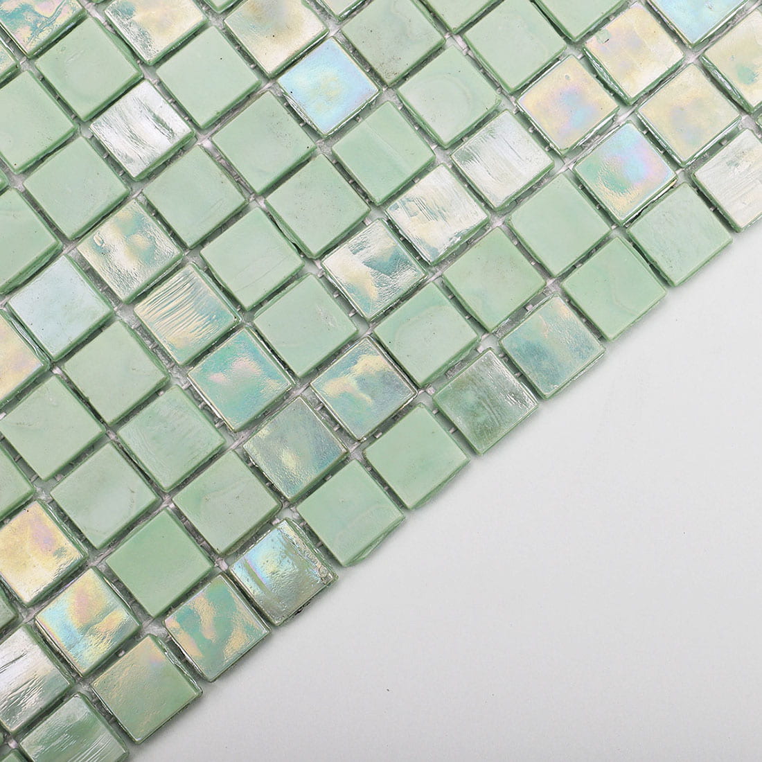 Close-up of mint green iridescent square glass mosaic tile surface