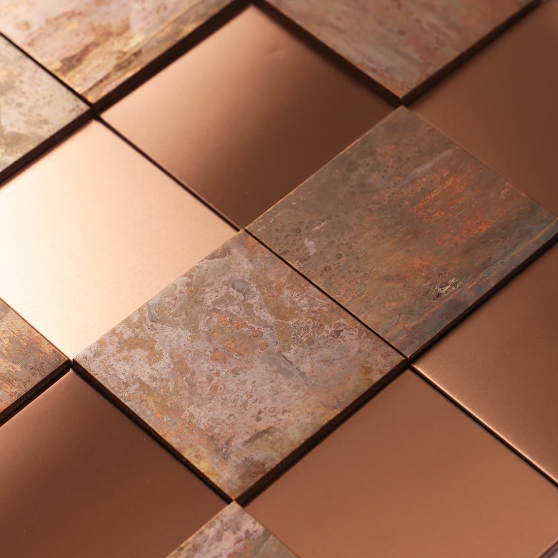 Close-up of mixed rose gold and antique copper square metal mosaic tile surface
