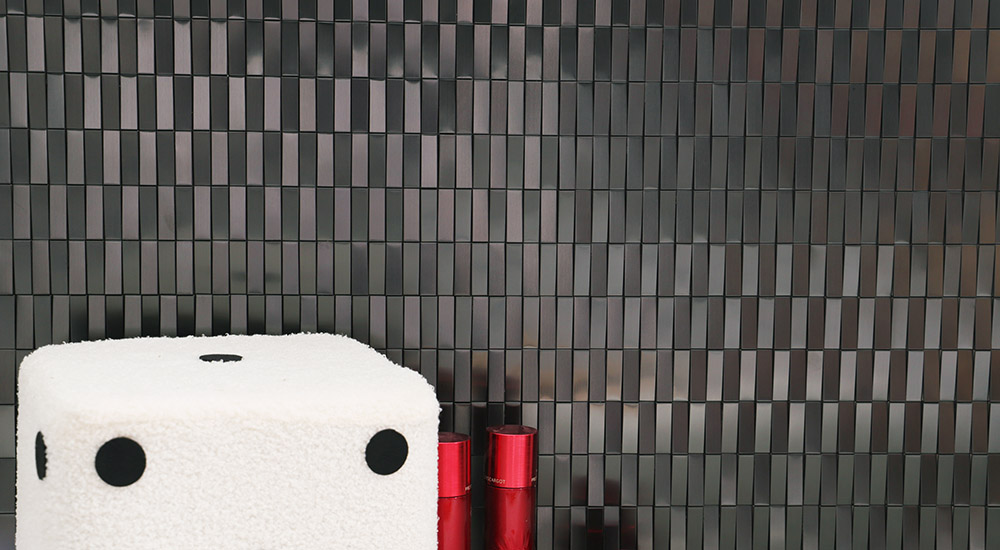{"default":"Front view of textured black metallic wall tiles in a contemporary stacked pattern."}
