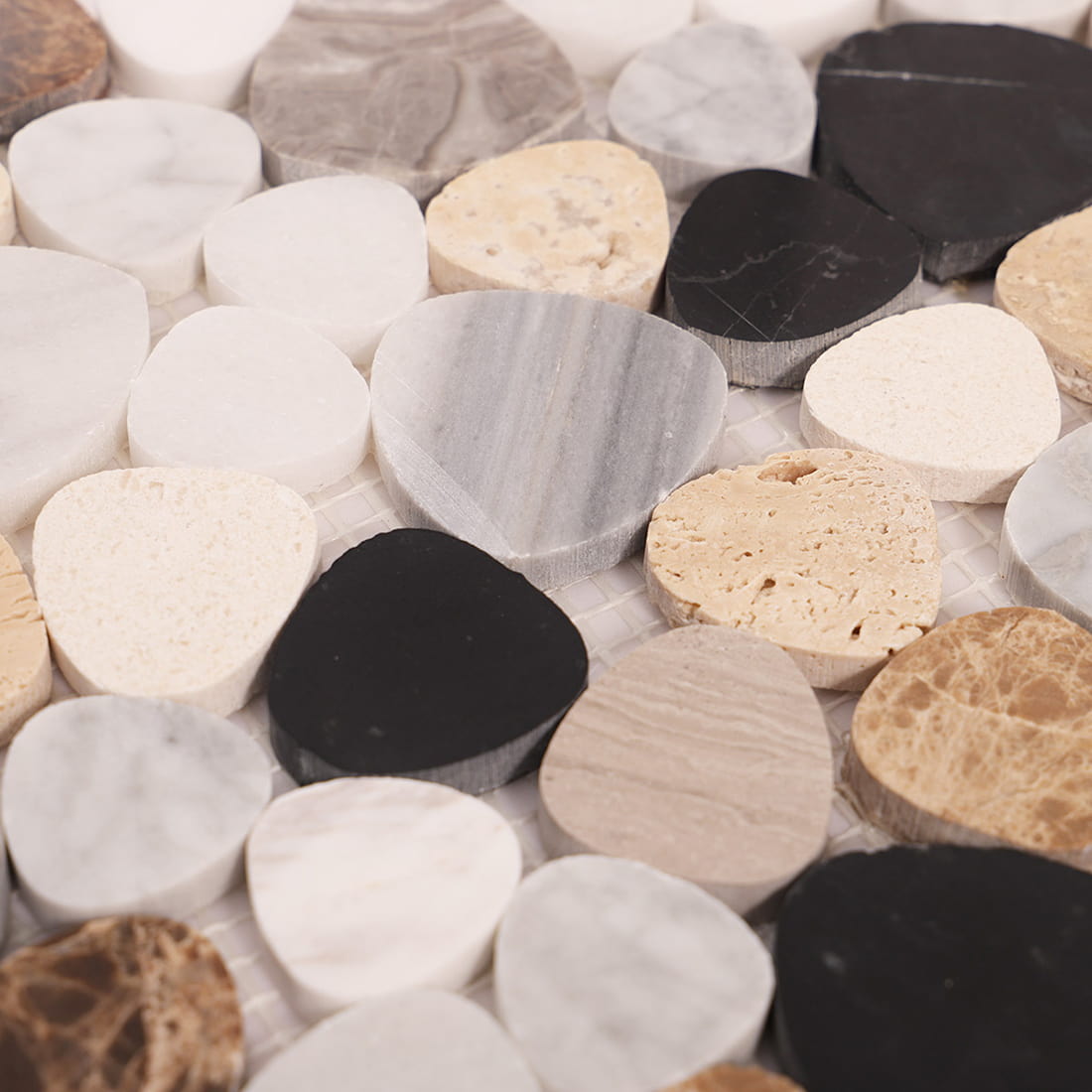 Surface detail of mixed pebble marble mosaic tiles in white gray beige and black