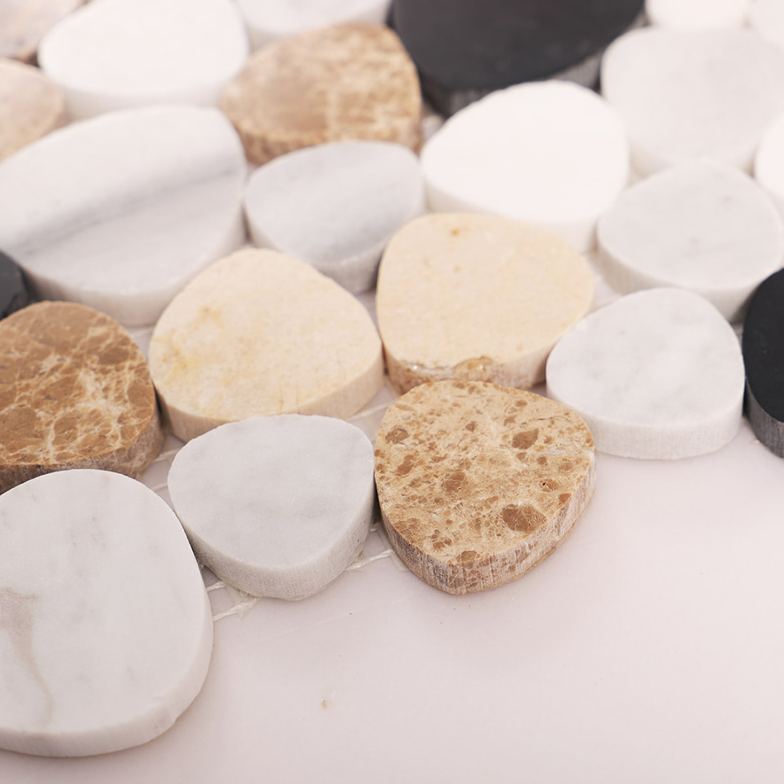 Side view showing the thickness and raised profile of pebble marble mosaic tiles