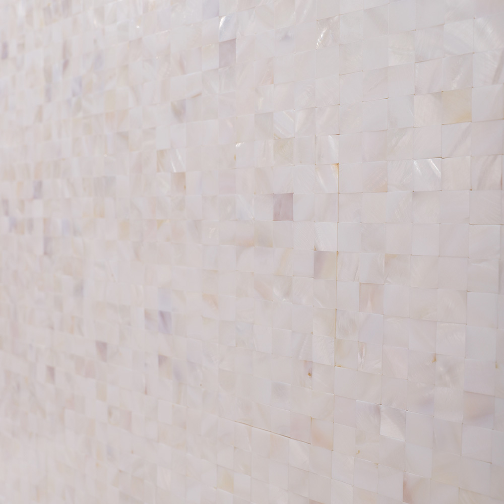 Angled close-up of white shell square mosaic tile wall.