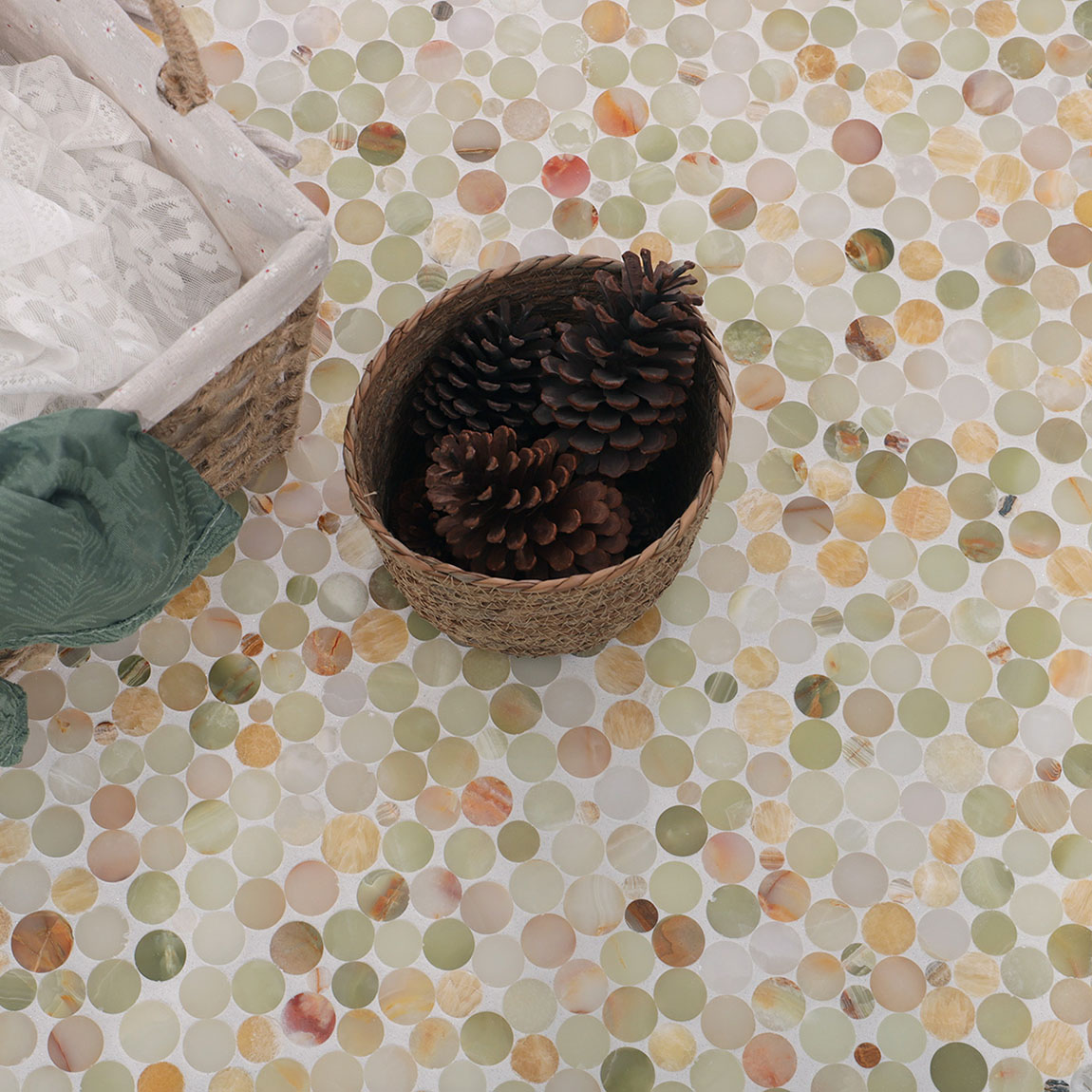 Top down view of onyx round mosaic backsplash with decorative pinecones