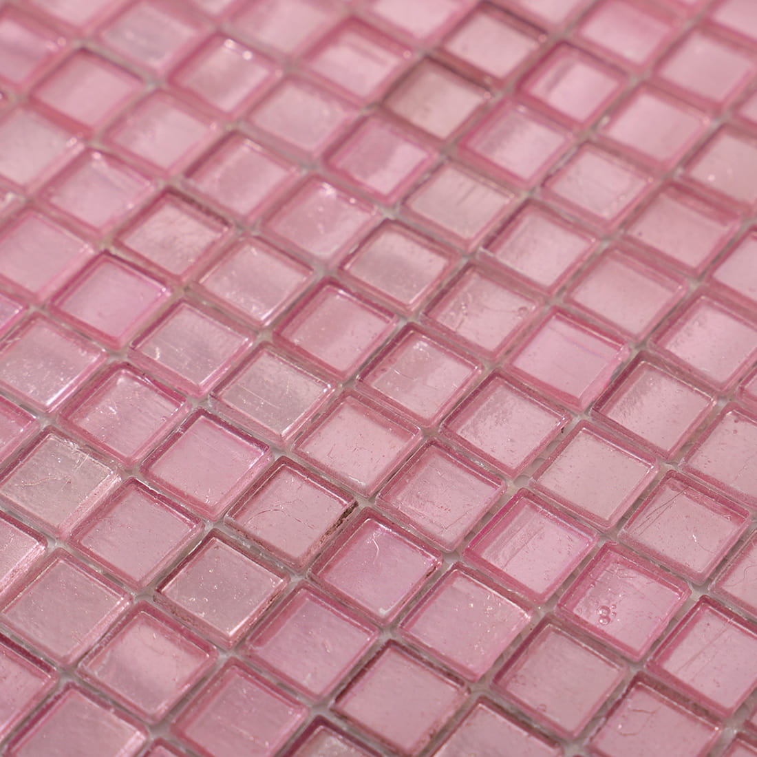 Angled detail of pale pink foil-backed square glass mosaic sheet
