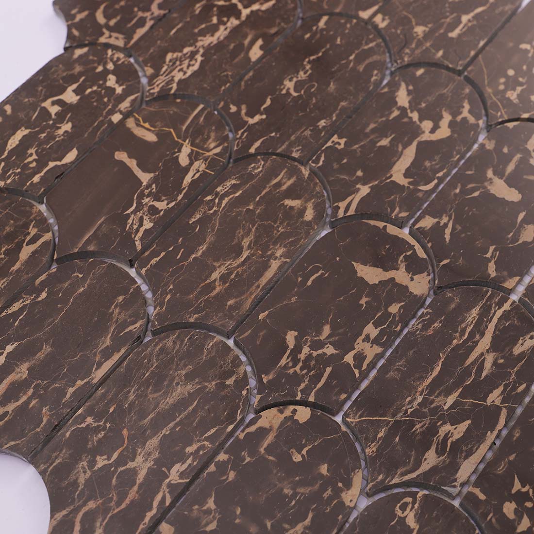 Polished surface of brown and gold marble fan shaped mosaic tiles
