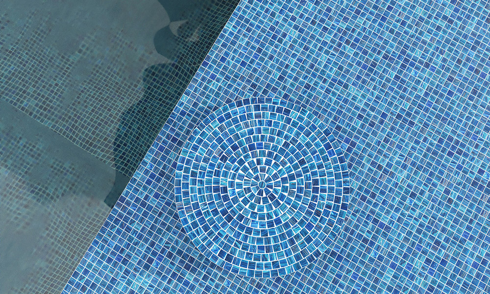 {"default":"Pool Tiles: Shimmering blue glass mosaic with a decorative circular medallion inlay."}
