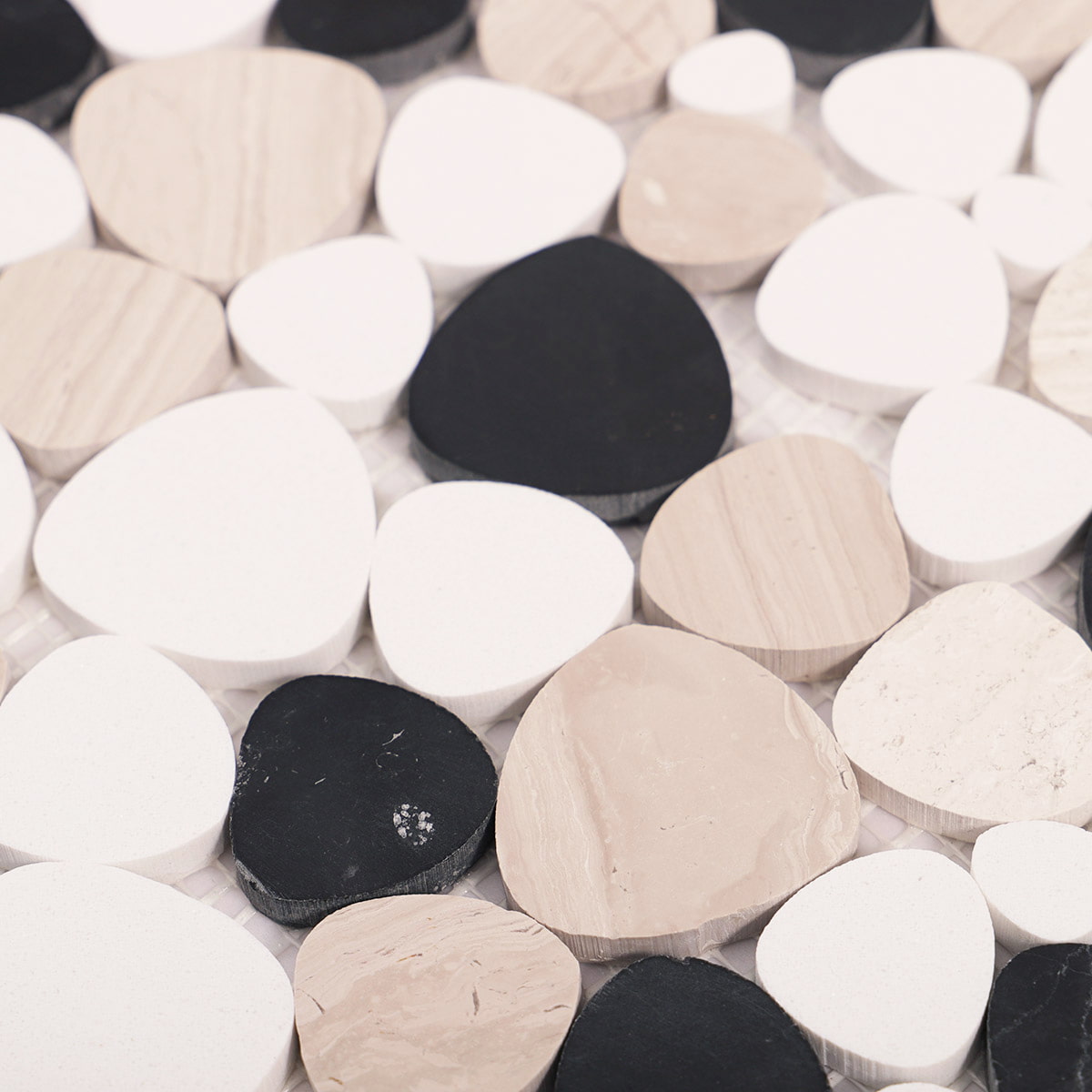 Macro texture of raised pebble mosaic tiles in black white and beige