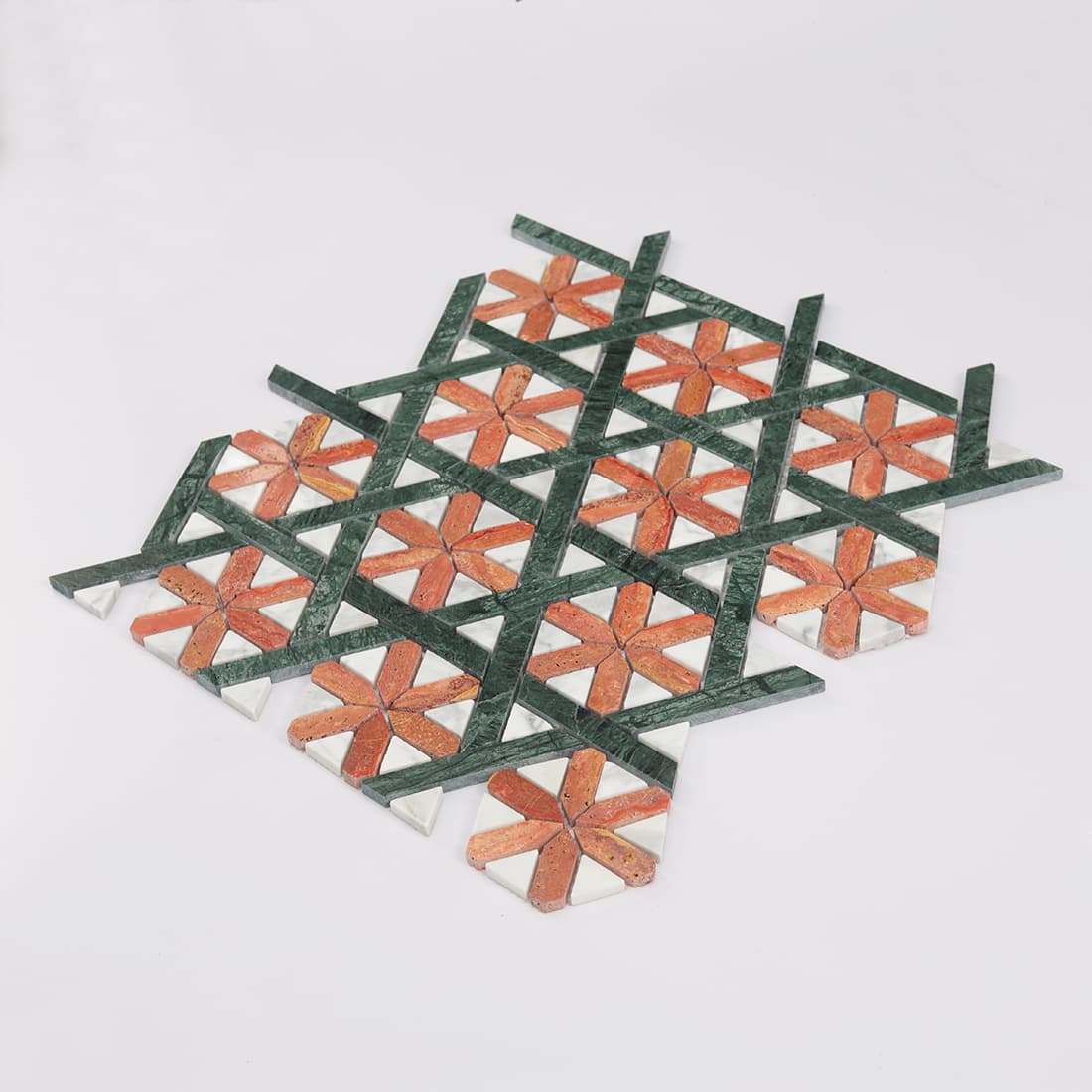 Angled view of geometric marble mosaic with red floral motifs and green bands