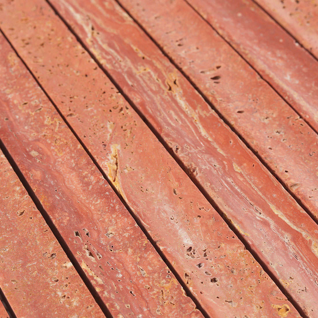 Surface texture and natural pits of red fluted travertine.