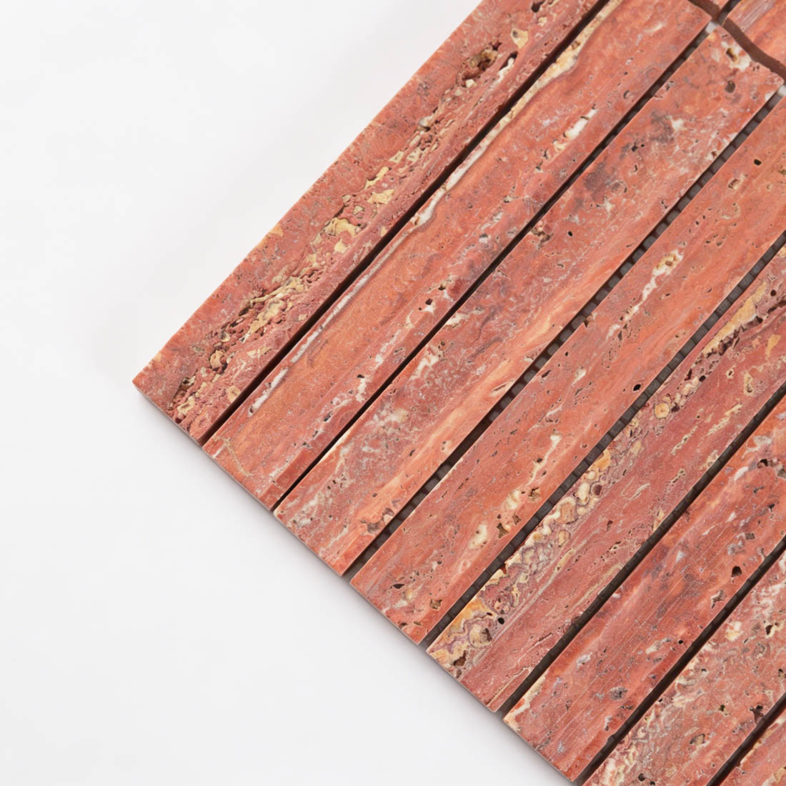 Corner detail of red travertine linear mosaic.