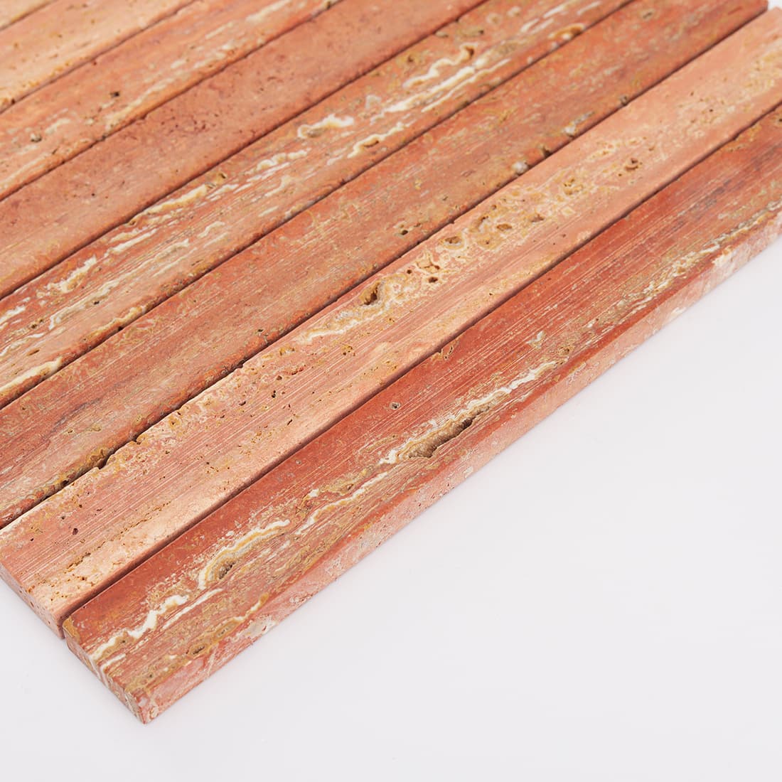 Angled edge view of red travertine stacked strip mosaic tile