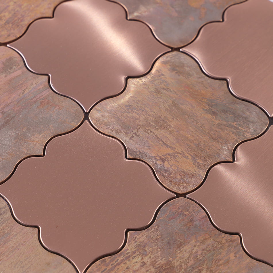 Close up of rose gold and antique copper arabesque mosaic tile surface