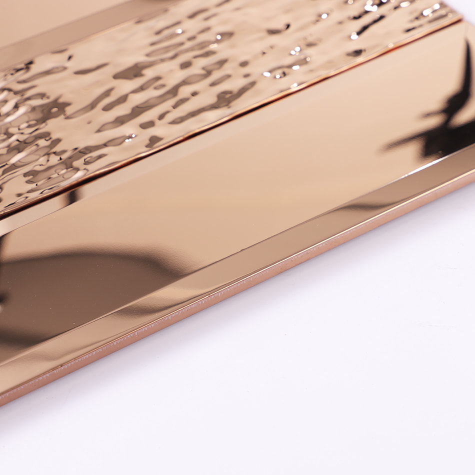 Edge detail of rose gold beveled textured metal wall tile