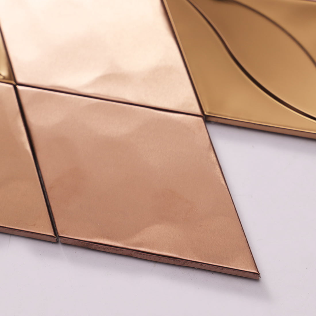 Macro view of rose gold diamond metal tile with hammered texture.