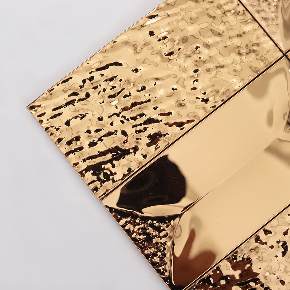 Close up of rose gold hammered rectangular metal mosaic with glossy finish