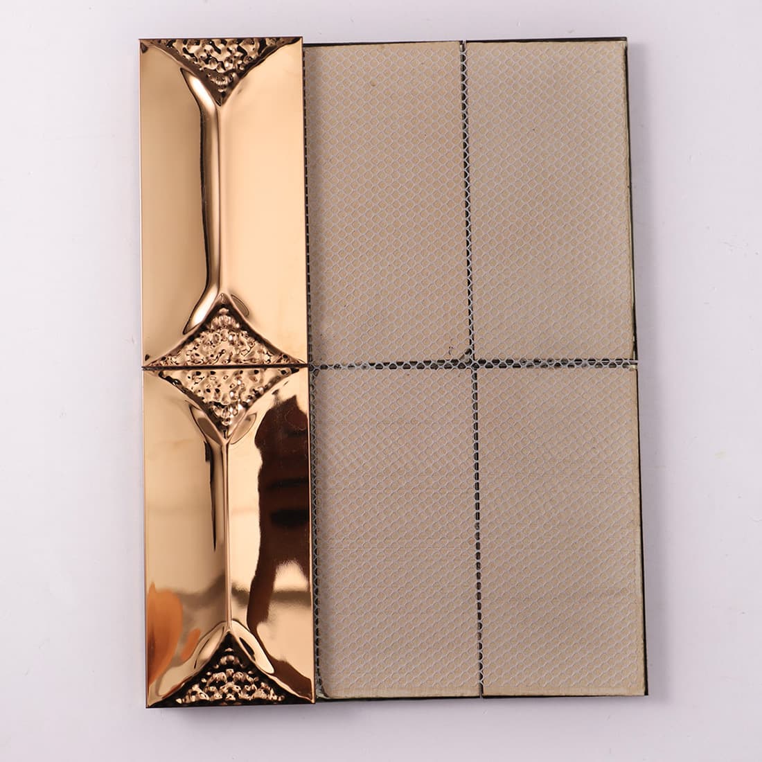 Display of rose gold metal mosaic tiles showing the fiber mesh backing.