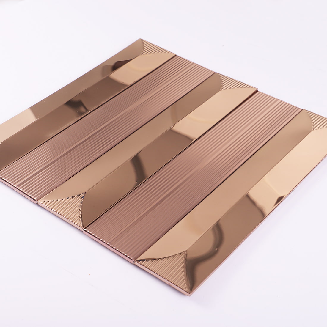 Angled view of rose gold mirror and fluted metal mosaic tile sheet