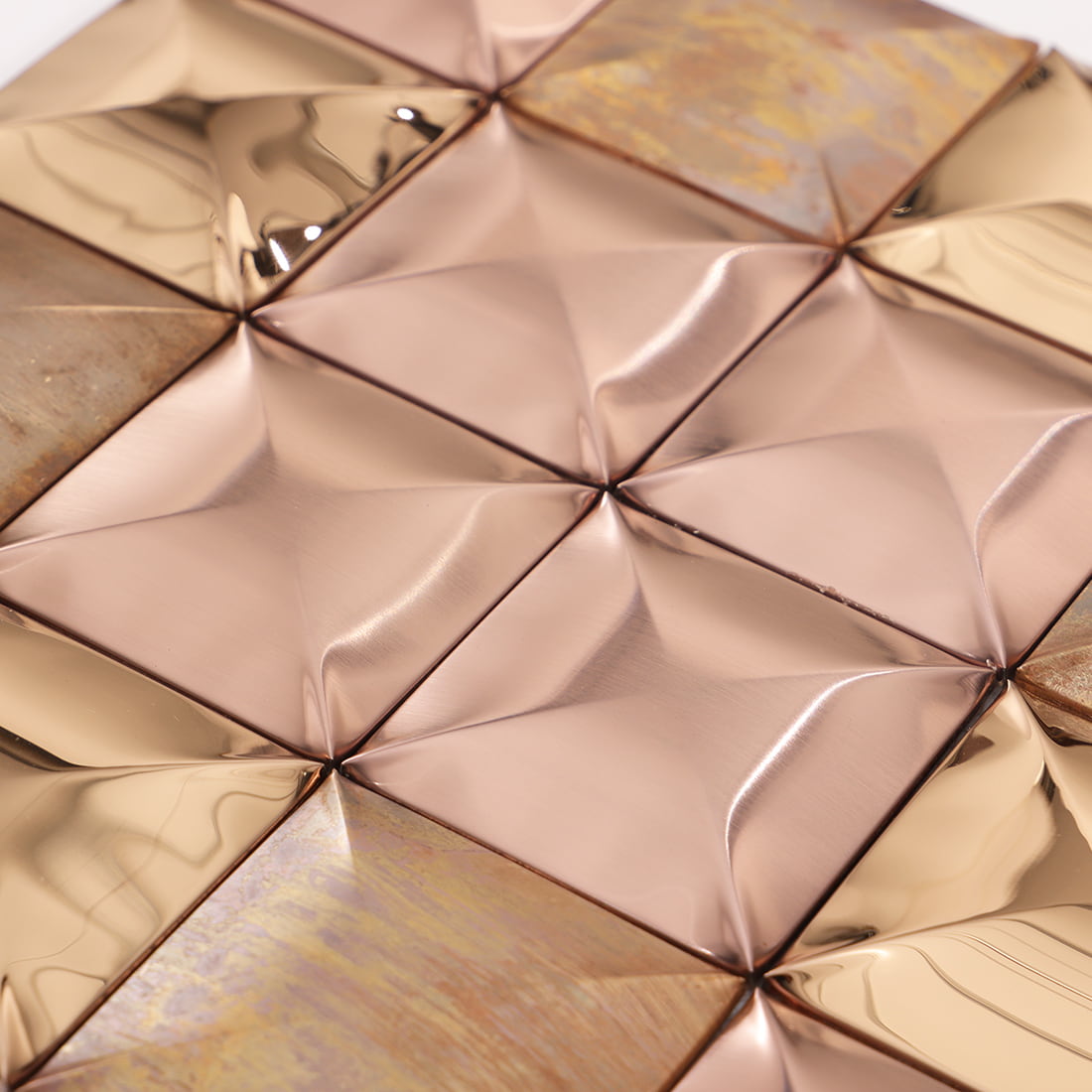 Close up of rose gold mixed metal square 3D mosaic tile surface