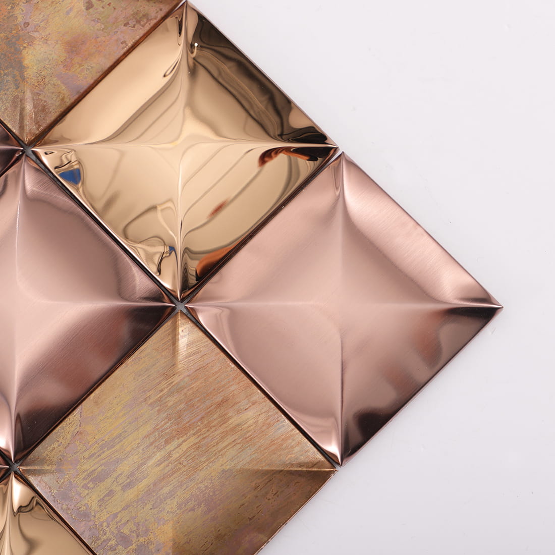 Corner detail of rose gold mixed metal square 3D mosaic tile