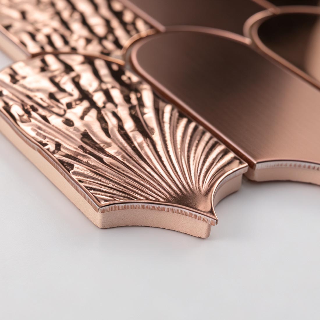 Detailed close up of rose gold scallop metal mosaic tile edges and surface finish
