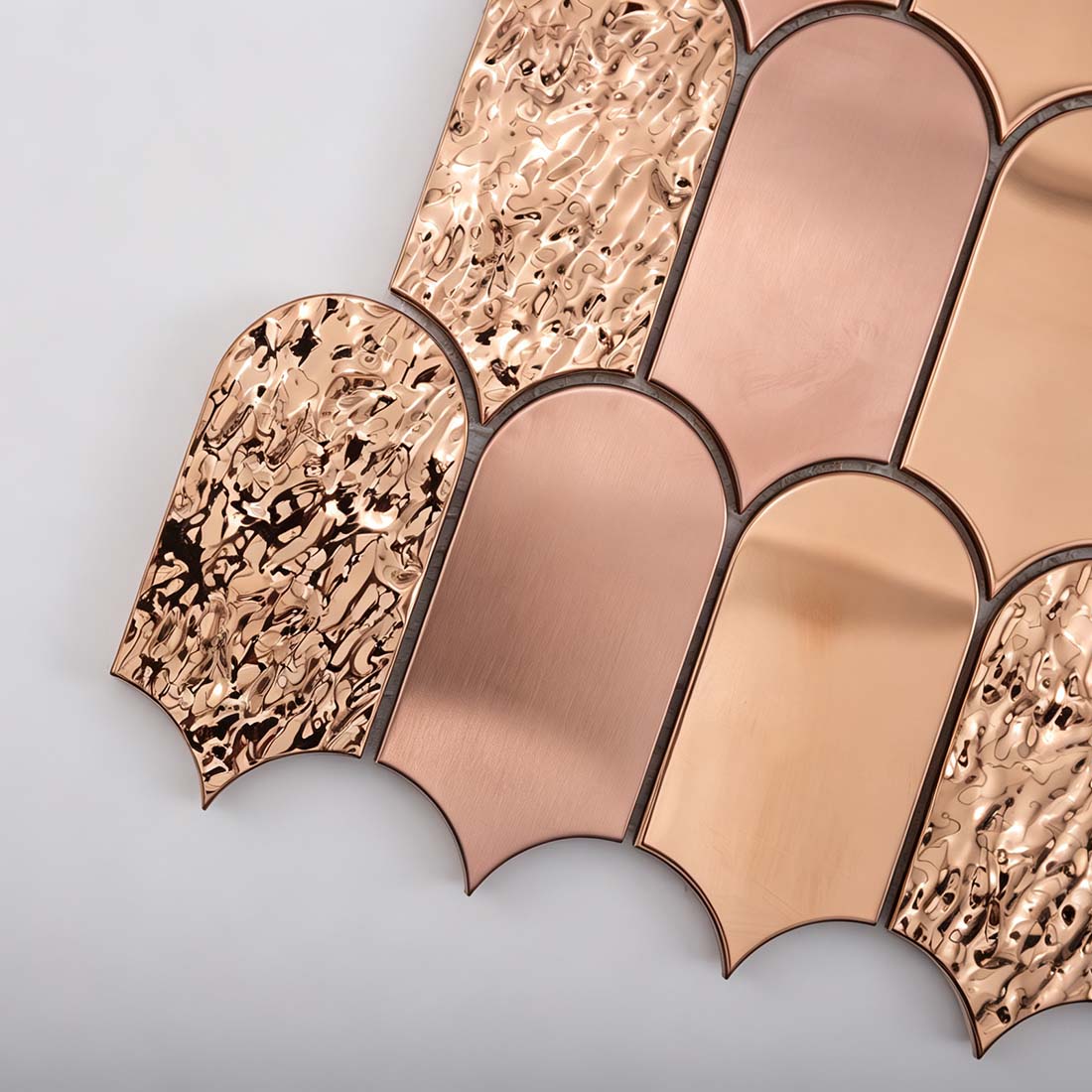 Close up of rose gold scallop metal mosaic tile textured individual chips