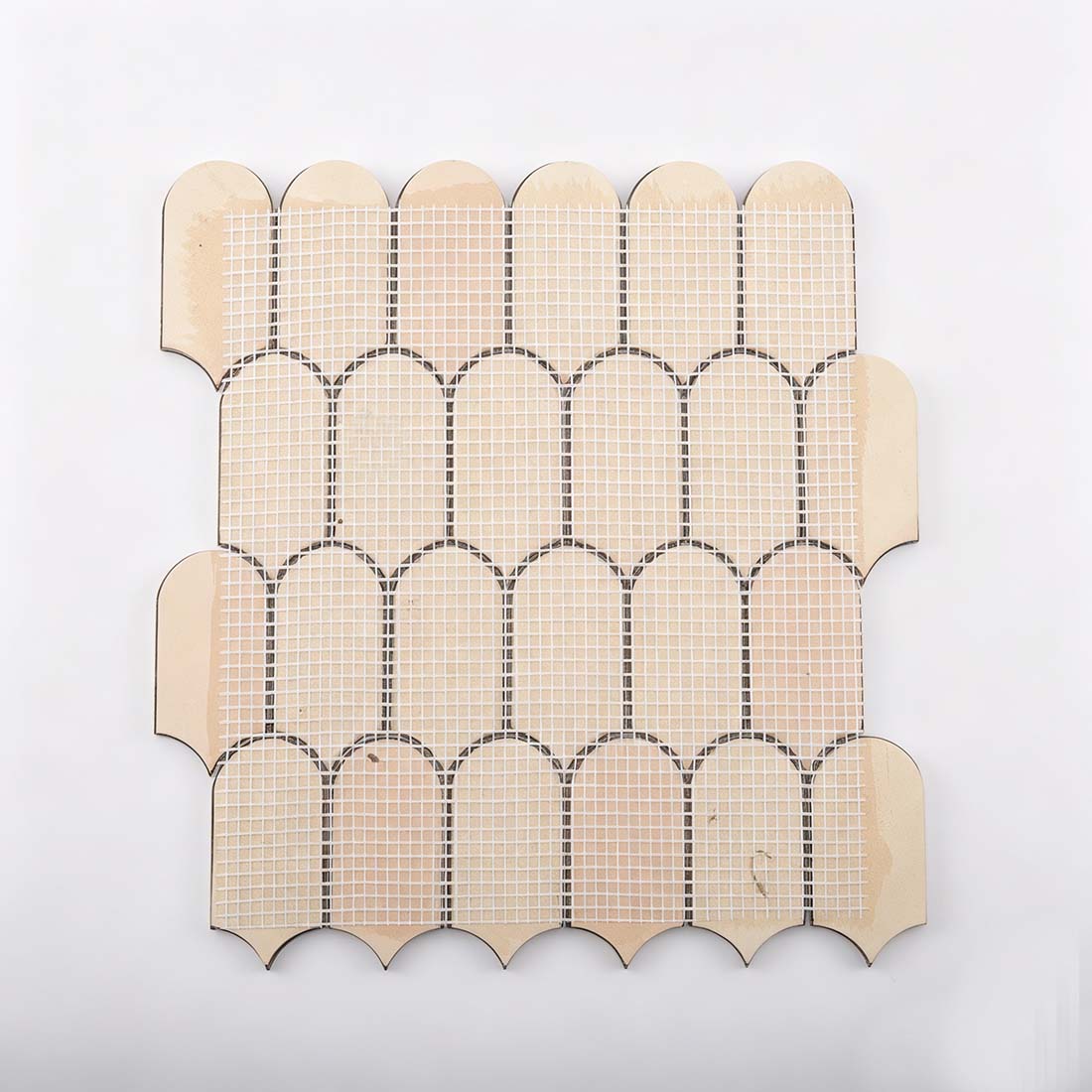 Fiberglass mesh backing on reverse side of rose gold scallop metal tile
