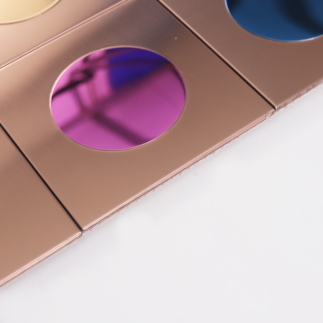 Edge detail of rose gold square metal tile with glossy pink round glass insert
