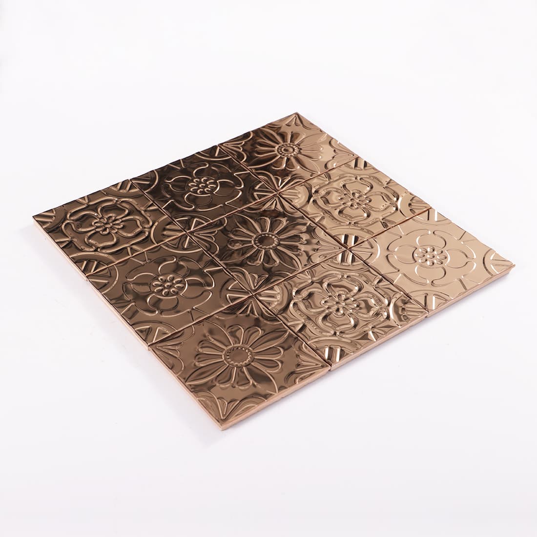 Angled view of rose gold stainless steel mixed floral embossed mosaic sheet