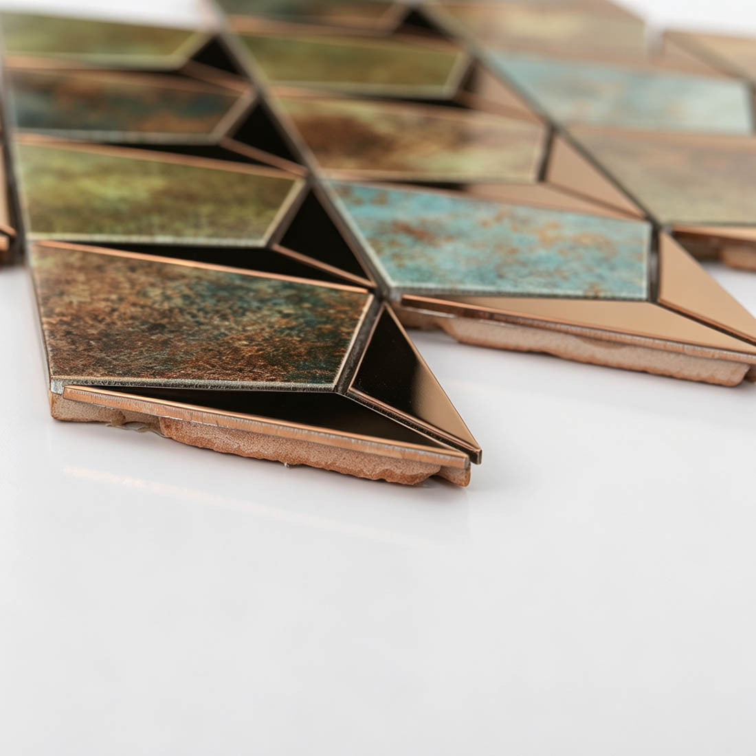Side view of rose gold teal kite-shaped aluminum mosaic tiles showing the tile base