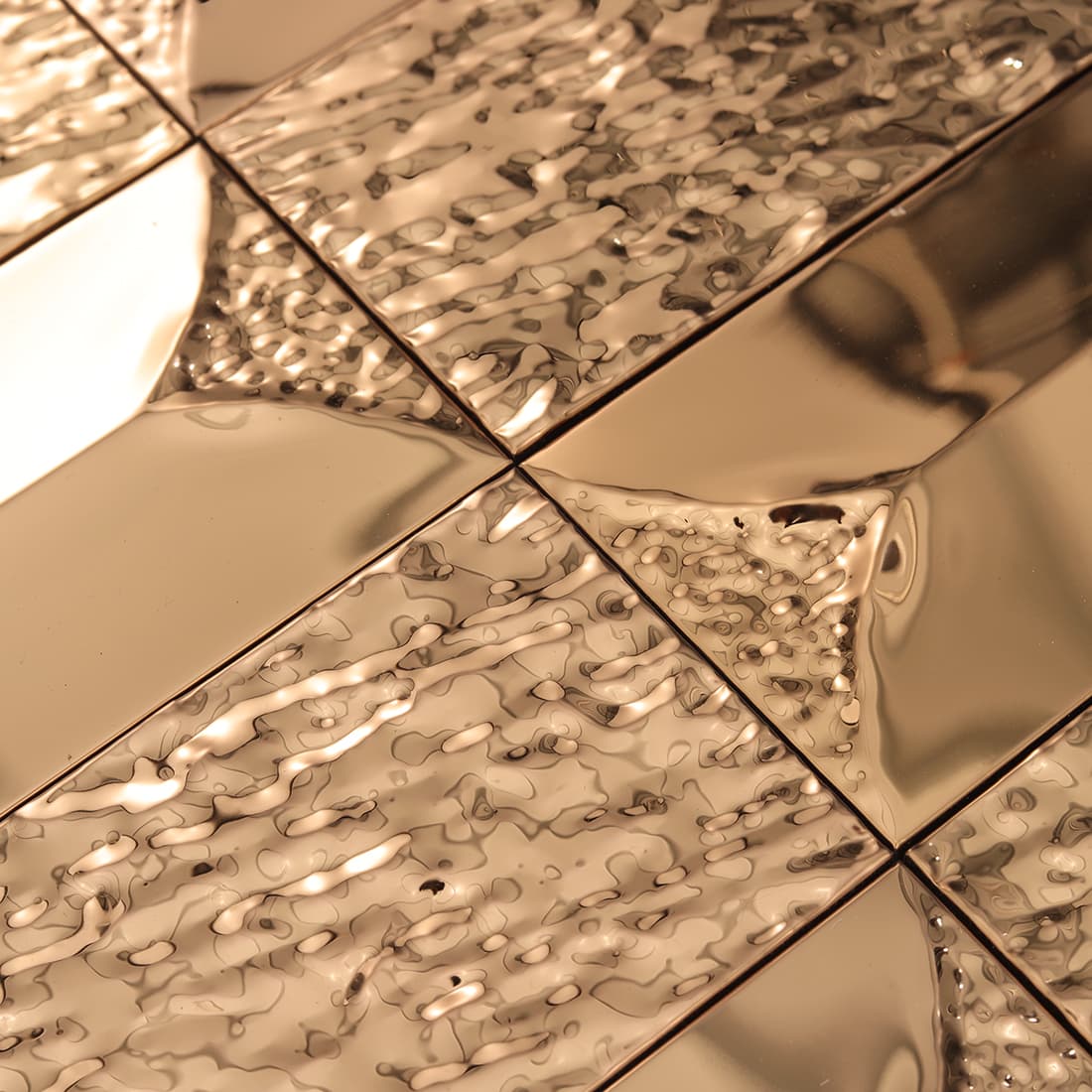Rose gold textured rectangular metal tile with reflective 3D surface