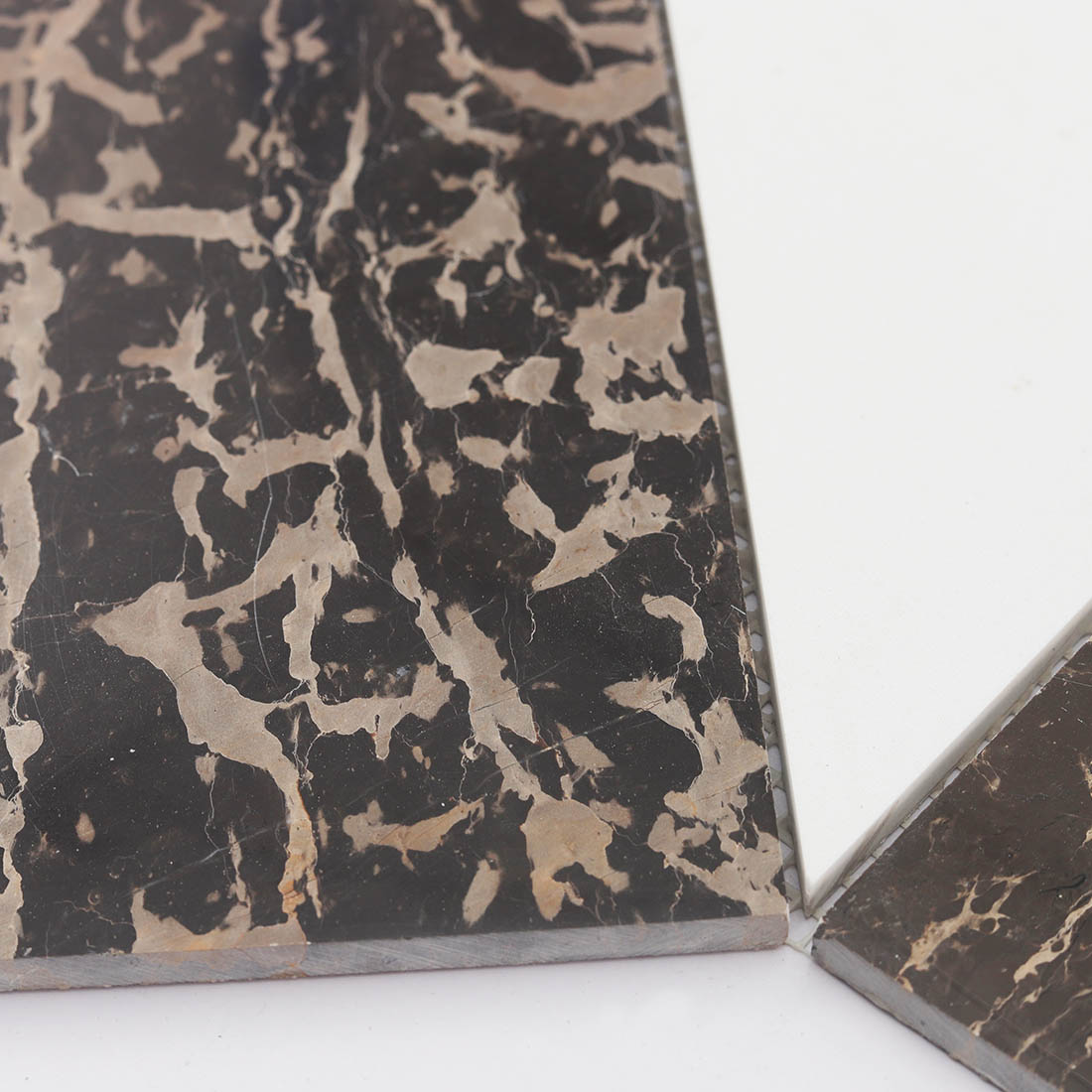 Close-up of brown veined marble and white geometric mosaic tile pieces