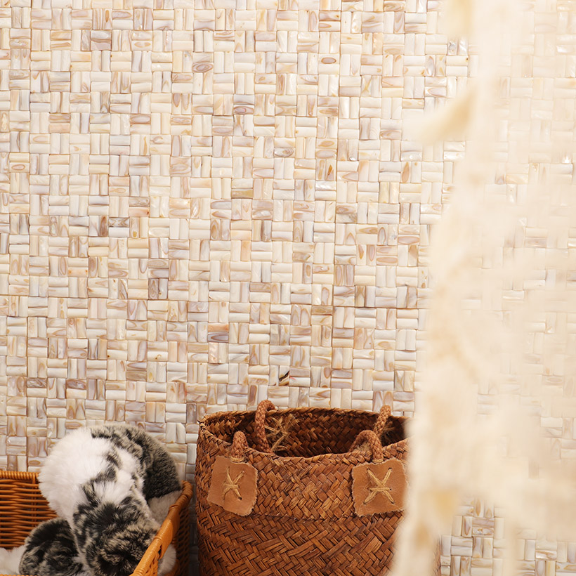 {"default":"Cream shell mosaic wall with woven baskets and soft decorative items in a cozy space"}
