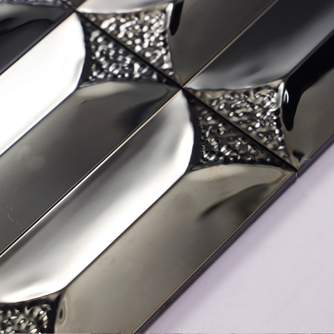 Side profile showing the 3D depth of black beveled metal tiles.