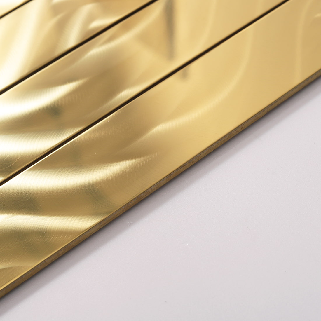 Side view of gold linear mosaic tile showing the thickness and texture.