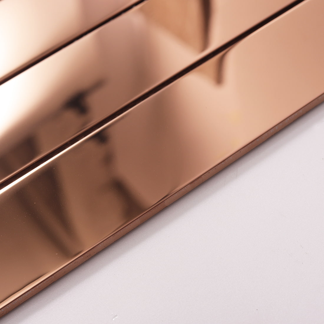 Side view showing the thickness and edge of rose gold glossy linear tile.