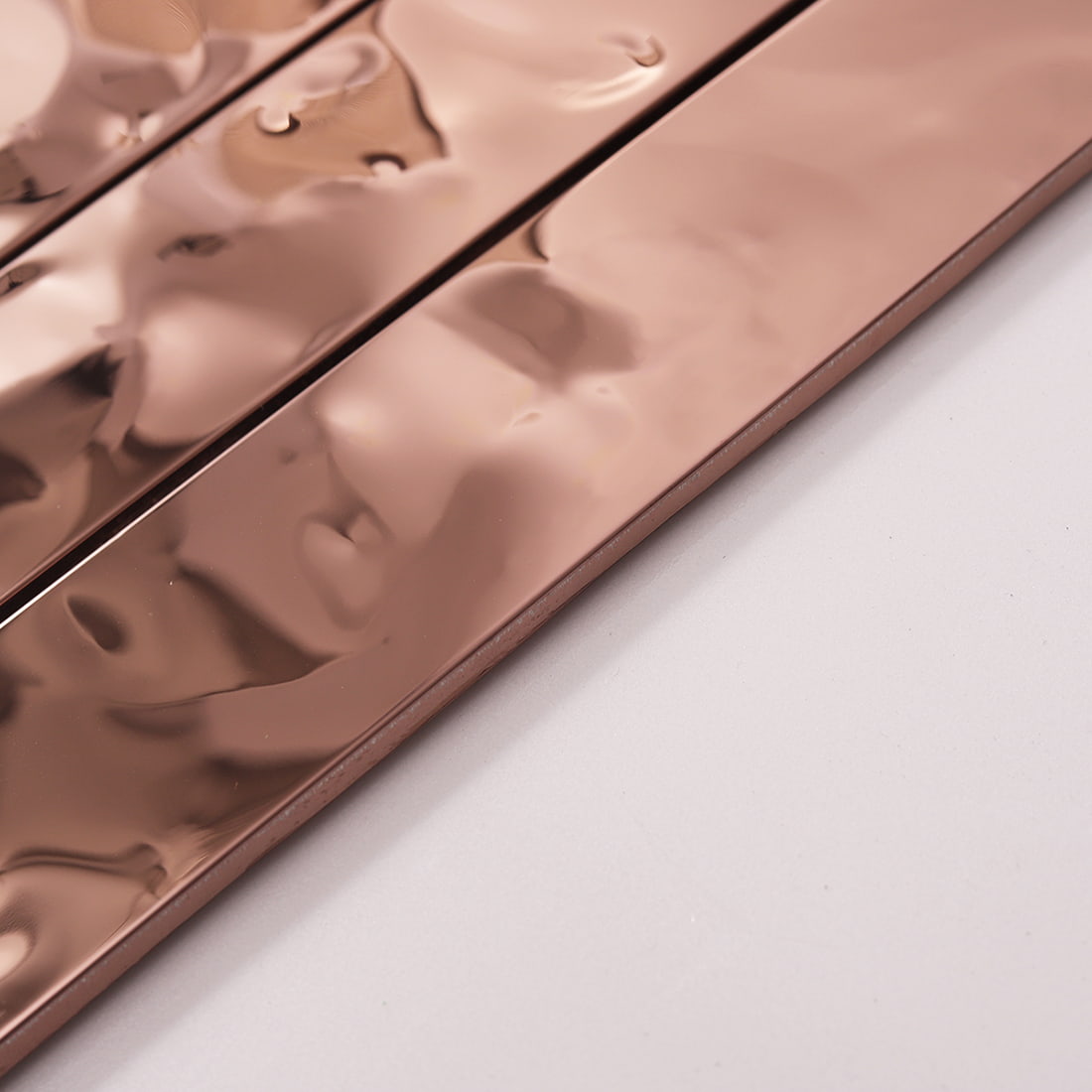 Side view showing the thickness and ripple surface of rose gold metal tile.