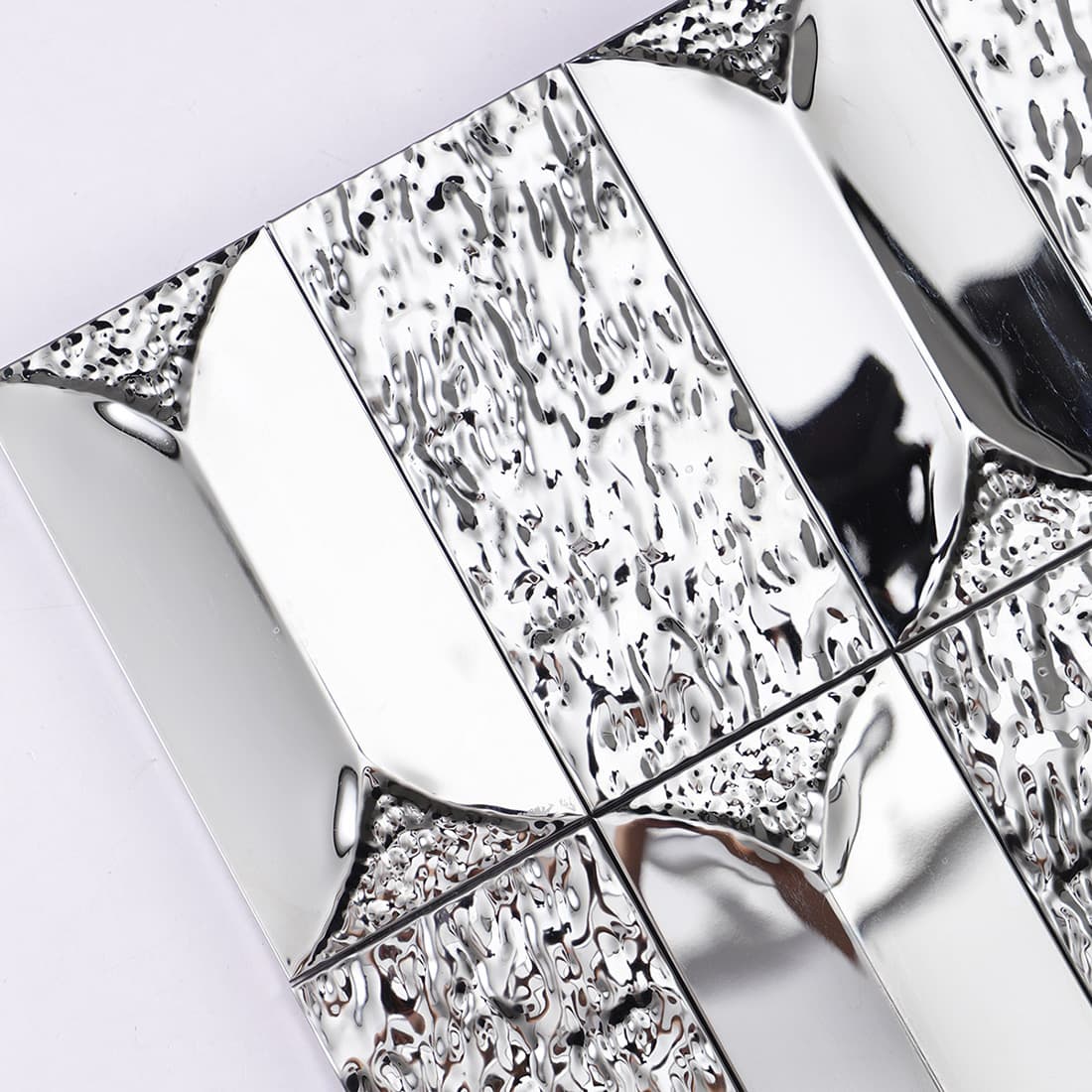 Detailed view of the water ripple texture on silver 3D metal tiles.