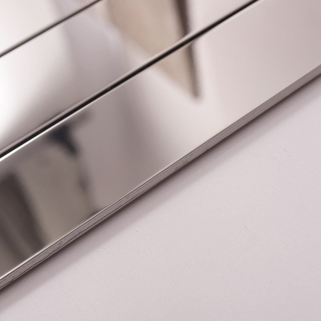 Side view showing the thickness of silver glossy linear metal tile.